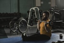 Homme handicapé faisant de l'exercice avec haltère dans la salle de gym — Photo de stock