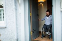 Людина з обмеженими можливостями закриває двері свого будинку — стокове фото