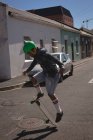 Man doing ollie trick on skateboard in street in sunlight — Stock Photo