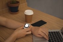 Geschäftsfrau nutzt Smartwatch am Schreibtisch im Büro — Stockfoto