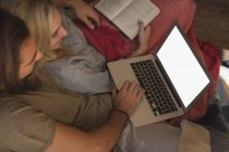 Пара використовує ноутбук у вітальні вдома — стокове фото