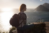 Beautiful redhead woman sitting at observation point in sunlight — Stock Photo