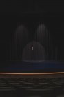 Female actor standing behind curtain on stage at theatre. — Stock Photo