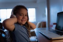 Smiling girl listening to music on headphones at home — Stock Photo