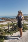 Radfahrerin trägt an einem sonnigen Tag ihren Helm in Strandnähe — Stockfoto
