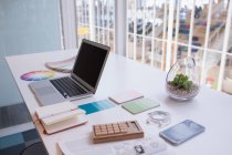 Ноутбук і кольоровий годинник за столом в офісі — стокове фото
