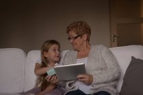 Бабуся і онука купують онлайн на цифровому планшеті вдома — стокове фото