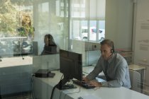 Бизнесмен, работающий за компьютером на рабочем столе в офисе — стоковое фото