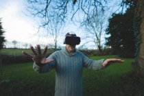 Homem usando headset realidade virtual na floresta no campo — Fotografia de Stock