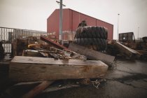 Tábua de madeira e pneu no estaleiro perto do estaleiro — Fotografia de Stock