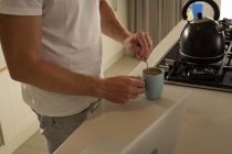 Середина чоловіка готує каву на кухні вдома — стокове фото