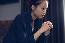 Close-up of thoughtful woman sitting in hotel — Stock Photo