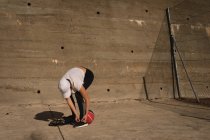 Frau bindet an einem sonnigen Tag Schnürsenkel im Basketballfeld — Stockfoto