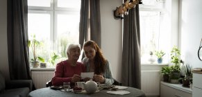 Бабушка и внучка смотрят на фото в гостиной — стоковое фото
