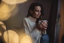 Bella donna che tiene una tazza di caffè a casa — Foto stock