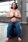Mulher grávida realizando ioga na bola de exercício — Fotografia de Stock