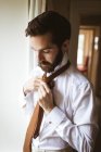 Nahaufnahme eines gutaussehenden Mannes, der seine Krawatte bindet — Stockfoto
