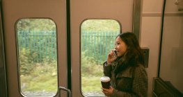 Femme parlant sur son téléphone portable pendant qu'elle voyageait dans le train — Photo de stock