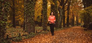 Жінка біжить в лісі під час автомного сезону — стокове фото