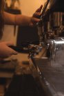 Обрезанный образ баристы, делающей кофе в кафе — стоковое фото