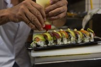 Primo piano dello chef che organizza il sushi in un vassoio del ristorante — Foto stock