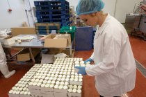 Trabajadora empacando botellas en la fábrica de alimentos - foto de stock