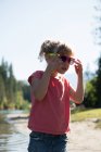 Niedliches Mädchen mit Sonnenbrille in der Nähe des Flussufers an einem sonnigen Tag — Stockfoto
