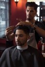 Mann lässt sich beim Friseur die Haare mit Schere schneiden — Stockfoto