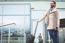 Businessman standing with trolley bag outside the hotel — Stock Photo
