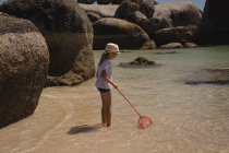 Дівчина риболовля з сіткою в морі в сонячний день — стокове фото
