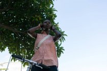 Жінка в навушниках на вулиці міста в сонячний день — стокове фото