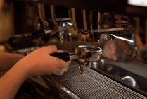 Barista hält Portafilter in der Nähe von Espressomaschine in Café gefüllt — Stockfoto