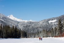 Pareja caminando juntos en el paisaje nevado durante el invierno - foto de stock