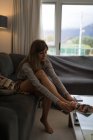 Jovem mulher vestindo meias na sala de estar em casa . — Fotografia de Stock