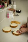 Primer plano de la mujer preparando comida dulce en la panadería - foto de stock