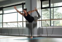 Mulher praticando ioga no tapete de exercício no estúdio de fitness
. — Fotografia de Stock