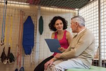 Terapeuta mujer discutiendo con un hombre mayor en un asilo de ancianos - foto de stock