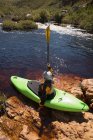 Femme se préparant pour le kayak dans la rivière au soleil . — Photo de stock
