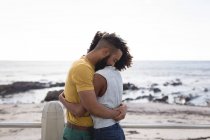 Casal romântico abraçando uns aos outros perto da praia em um dia ensolarado — Fotografia de Stock