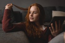 Nachdenkliche Frau nutzt digitales Tablet zu Hause — Stockfoto