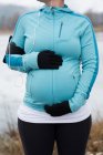 Parte média da mulher grávida tocando sua barriga no parque — Fotografia de Stock