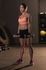 Mujer en forma haciendo ejercicio con pesas en el gimnasio - foto de stock