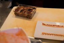 Assiette de service Sushi garnie de sauce gardée sur une planche à découper — Photo de stock