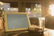 Tavoletta digitale e colazione sul tavolo nel caffè — Foto stock