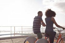 Романтическая пара наслаждается велосипедной прогулкой возле пляжа — стоковое фото