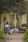 Donna che legge libro in portico — Foto stock