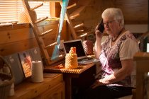 Старшая женщина разговаривает по мобильному телефону в магазине — стоковое фото