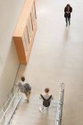 Високий кут зору студентів коледжу, які ходять по сходах — стокове фото