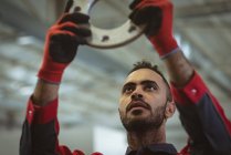 Männlicher Arbeiter überprüft Maschinenteil im Werkslager — Stockfoto