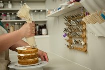 Nahaufnahme einer Frau bei der Zubereitung süßer Speisen in einer Bäckerei — Stockfoto